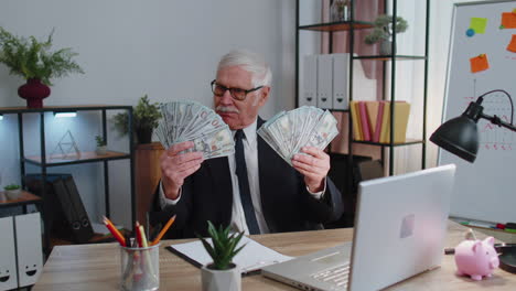 business man accountant celebrating business success dancing with stack of money dollar cash