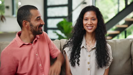una pareja feliz sentada en el sofá