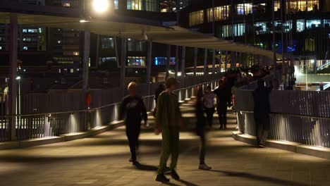 people crossing the river via neville bonner bridge connecting queen's wharf precinct in brisbane central business district to south bank parklands in south brisbane, urban night time-lapse shot.