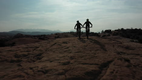 two unrecognizable athletic men mountain biking