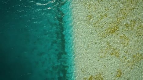 From-the-top-view-over-a-clear-blue-Caribbean-Sea-in-Los-Roques,-Venezuela