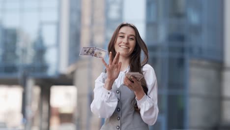 business lady scattering money on the background of a glass building