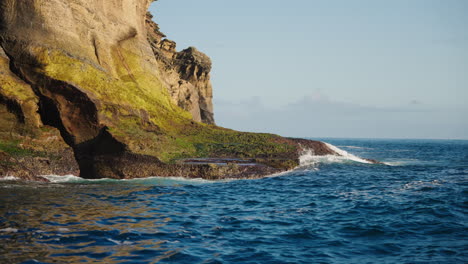 Slow-motion-shot-of-beautiful-tropical-coastline-cliffs-from-sea-level