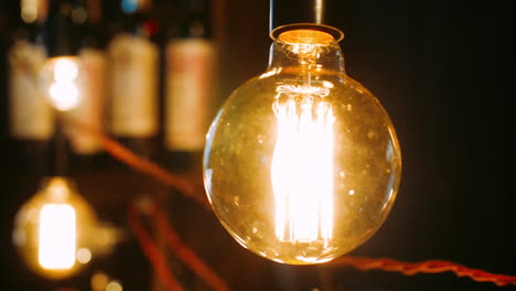 bright incandescent bulbs hang and shine in row. electric lights brightly shine