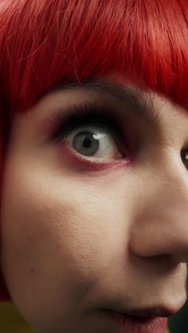 close-up of woman with red wig and vibrant makeup