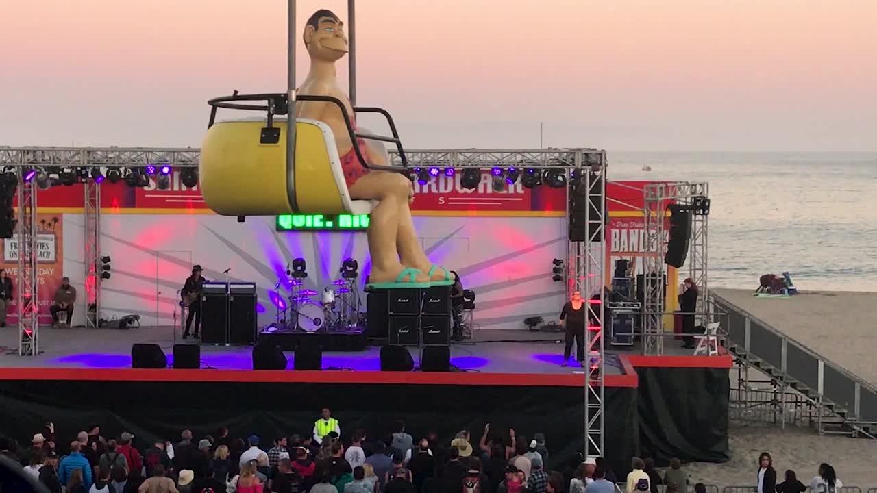 Concert on the beach at santa cruz beach boardwalk area evening time after sunset.  Quiet Riot music band performing-singing.
