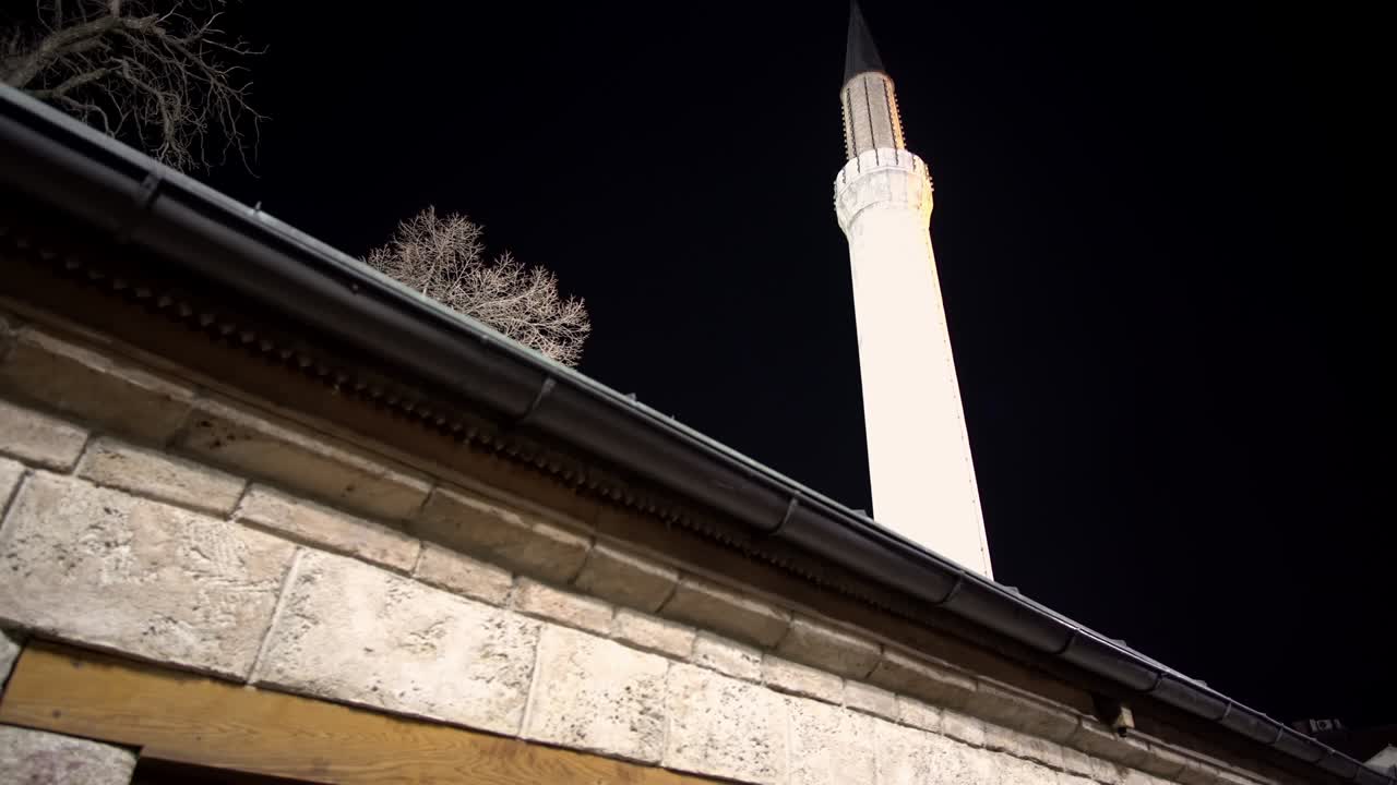 el minarete de la mezquita del emperador de estilo otomano en sarajevo por la noche, es la primera mezquita construida después de la conquista otomana de bosnia en 1457.