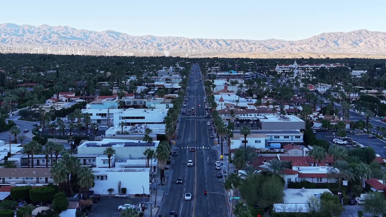 Riprese con drone ad alta quota che mostrano Palm Springs incastonata nel deserto, incorniciata da aspre catene montuose sotto cieli sereni.