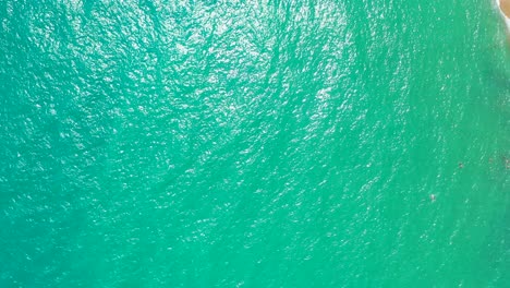 emerald seawater with the sun reflecting on the surface