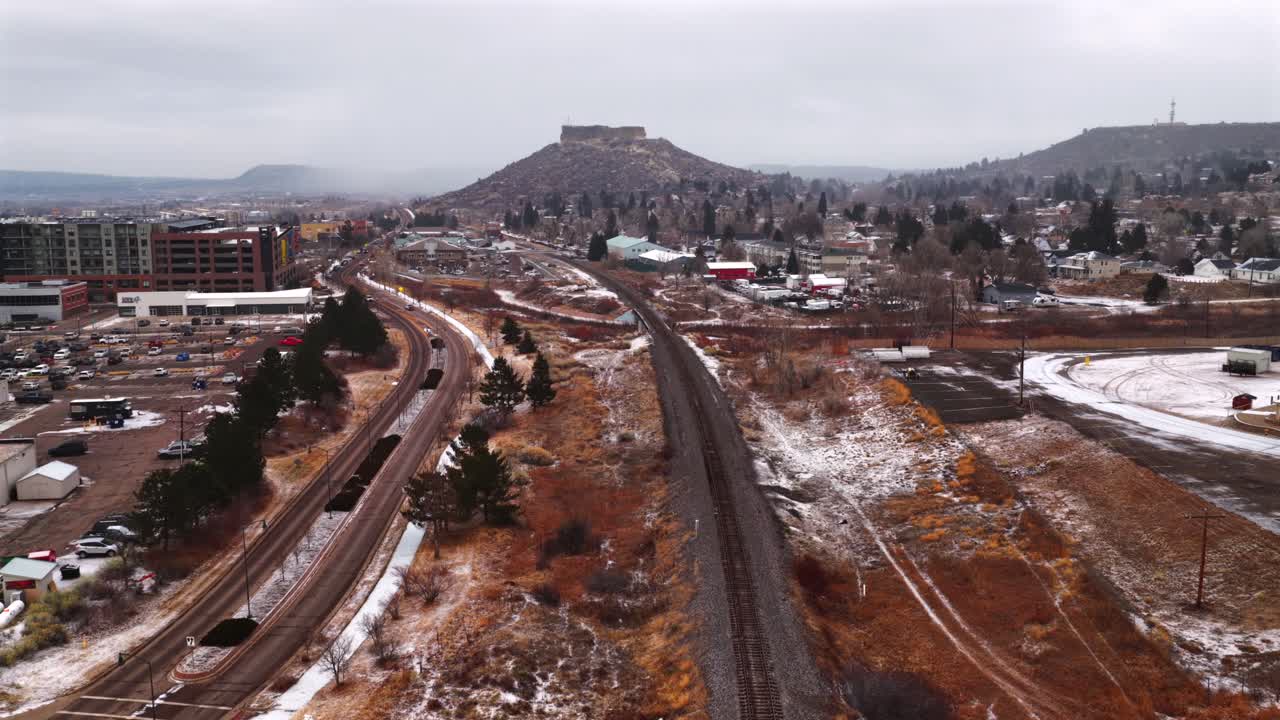 Città di Castle Rock, Colorado, ripresa aerea con drone: Front Range a sud di Denver, mesa innevata, mattina d'inverno nevosa, giornata nuvolosa con neve, auto, binari ferroviari, edifici, quartiere, centro, movimento di panoramica in avanti