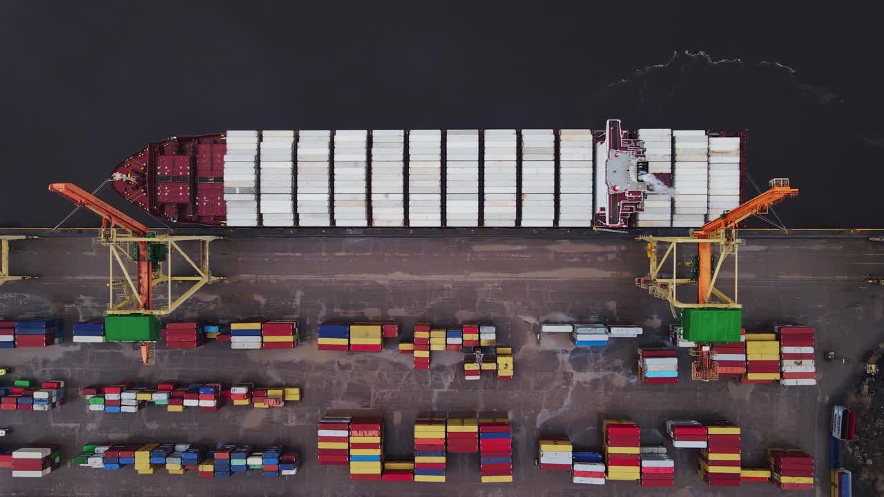 Drone slowly descends over a cargo ship, showcasing cargo operations in action