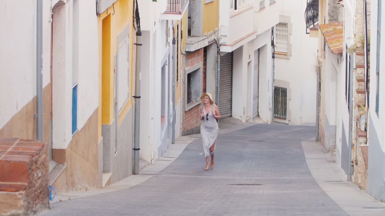 женщина турист верхпо узкой улице в старом квартале старого города лорет де мар испания туризм
