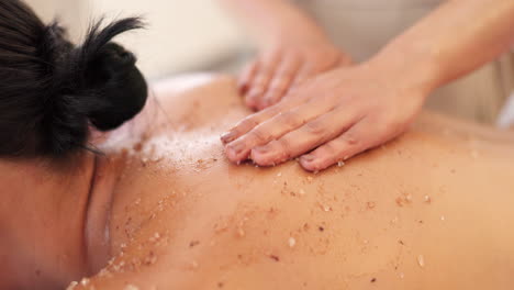 spa, masaje y exfoliación de sal en la espalda de la mujer