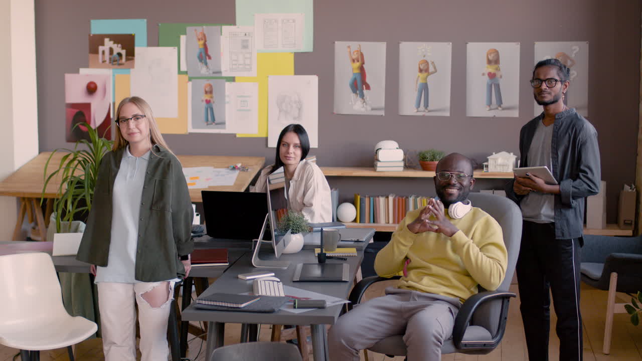애니메이션 스튜디오에서 카메라를 보고 웃는 그래픽 디자이너의 다민족 팀 4