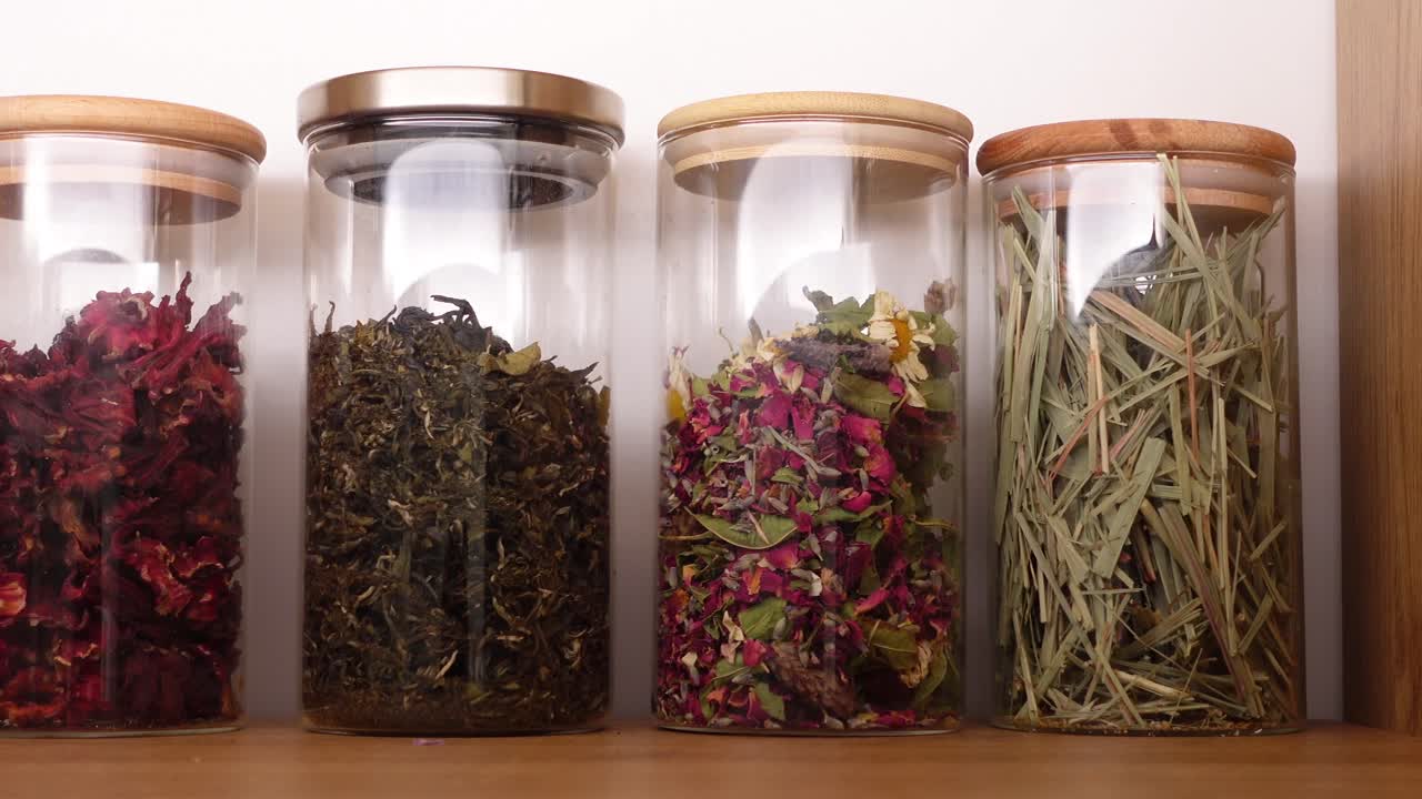 Assortimento di tisane essiccate e spezie in barattoli di vetro.