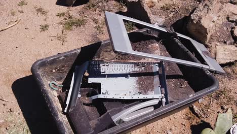 discarded broken television in a trash bin