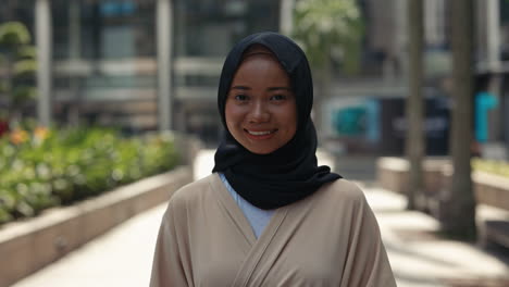 smiling muslim woman in hijab outdoors