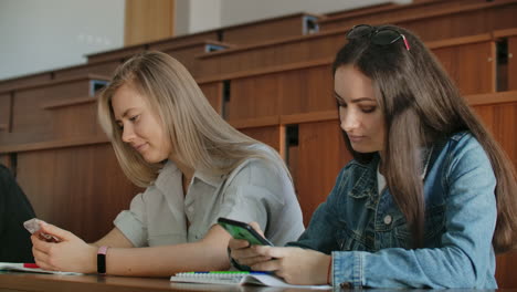 multi ethnic group of students using smartphones during the lecture. young people using social media while studying in the university