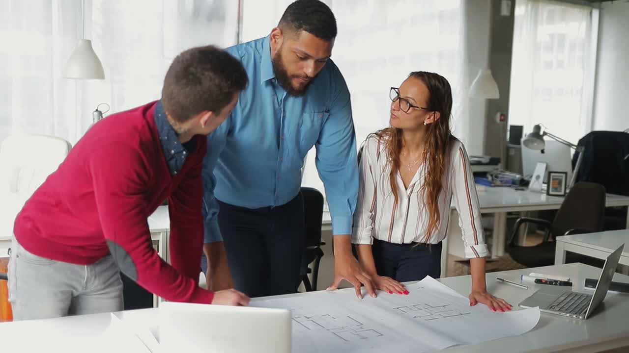 jefe concentrado explicando dibujos al personal.