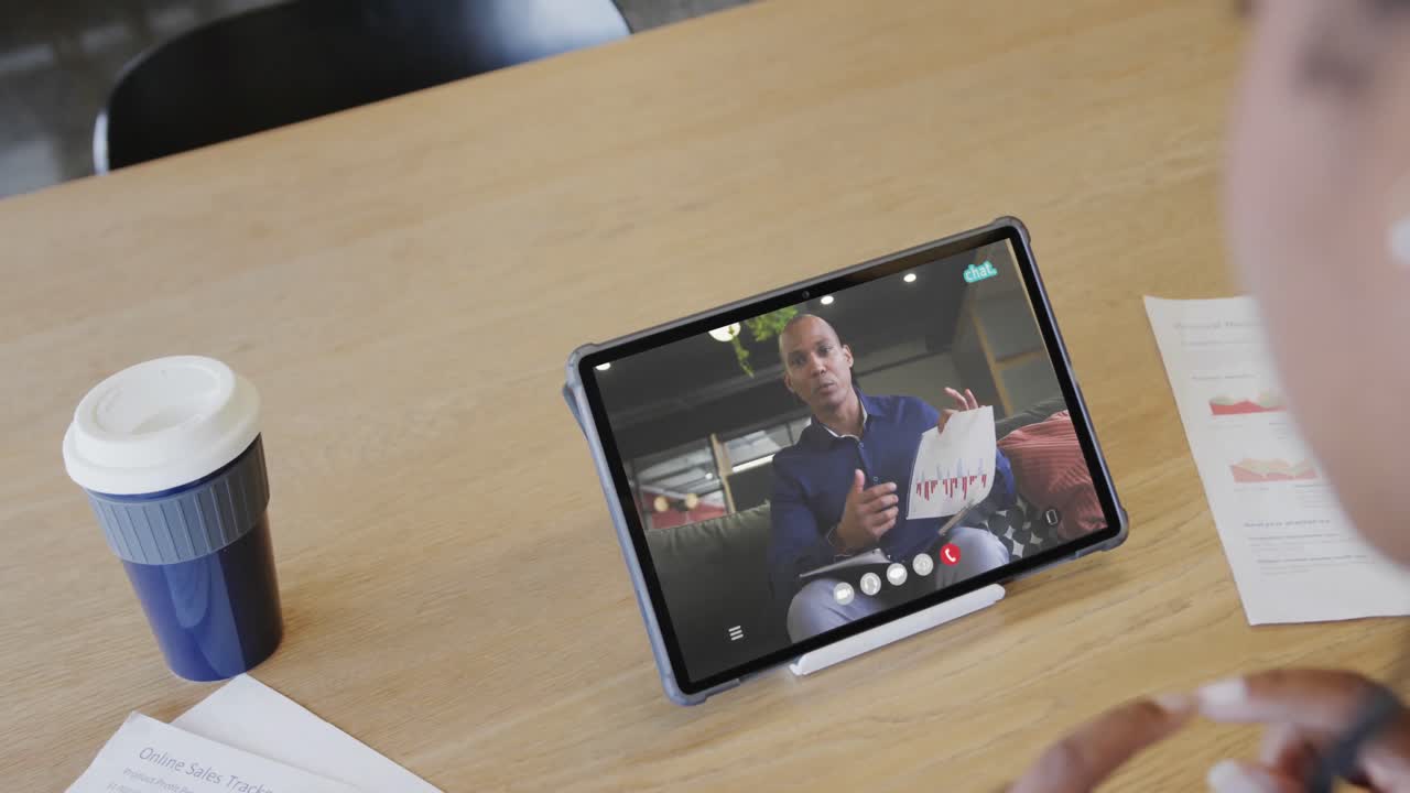 mujer de negocios caucásica en una videollamada con un colega afroamericano en la pantalla