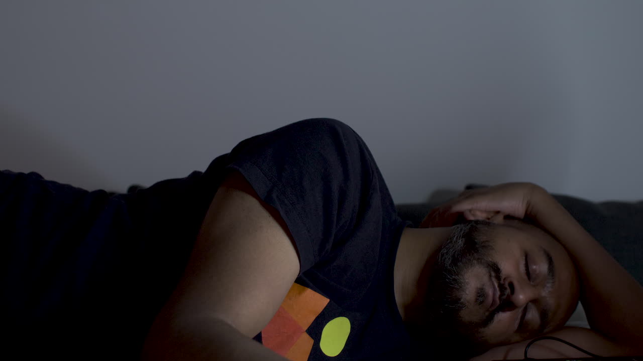 deprimido, cansado hombre asiático de mediana edad, acostado en la cama, sentimientos ansiosos