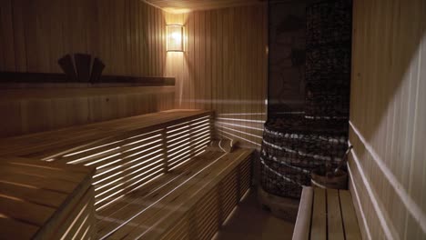 a wooden finnish sauna is lit by light.