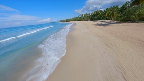 FPV-Luft-Fliegt-Tief-Entlang-Türkisblauer-Wellen,-Die-Auf-Die-Goldene-Sandbucht-Von-Coson-Beach,-Samana,-Dominikanische-Republik,-Krachen