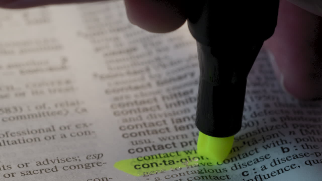 Contagion Pandemic Dictionary Highlighter Concept, highlighting a word in a dictionary to show it's definition