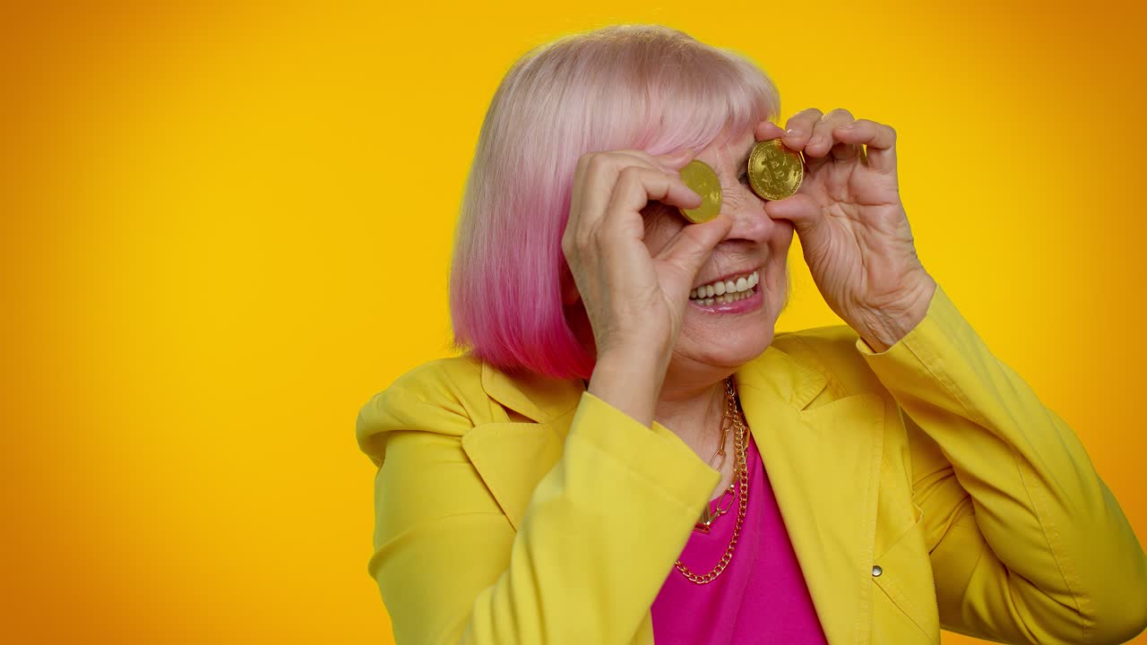 vieja abuela madura mujer elegante mostrando bitcoins dorados inversión en criptomonedas, tecnología de minería