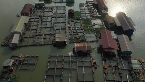 top down drone crane shot flying over floating fish farming community in bien hoa on the dong nai river, vietnam on a sunny day