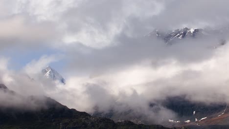 clouds over the snow capped mountains in glacier bay national park alaska