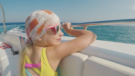 la chica de la bandana navega en un barco mira paisajes al agua vacaciones de verano con un niño