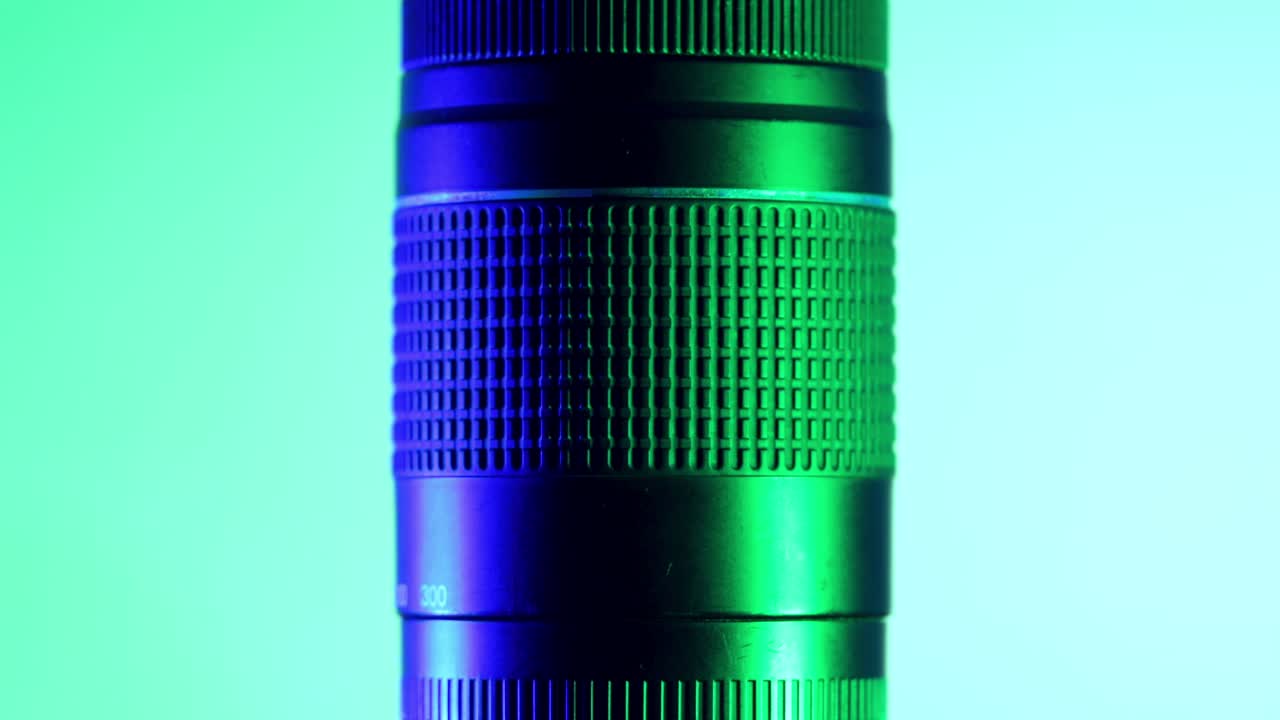 teleobjetivo profesional bajo luces verdes y azules, toma de estudio con movimiento giratorio