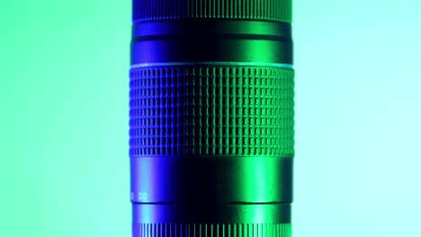 teleobjetivo profesional bajo luces verdes y azules, toma de estudio con movimiento giratorio