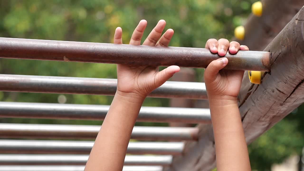 Child hanging on monkey bars