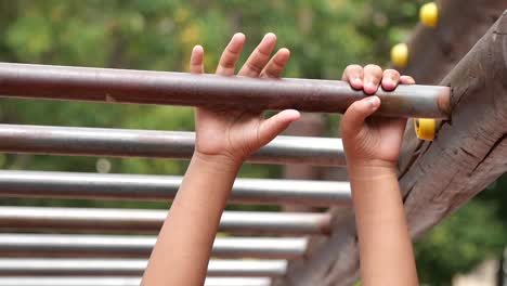 child hanging on monkey bars