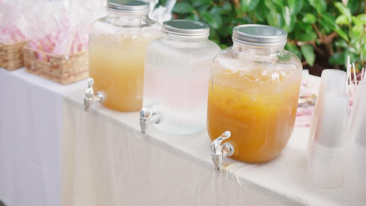 Jars of colorful baptismal juice outdoors, joyful and festive atmosphere