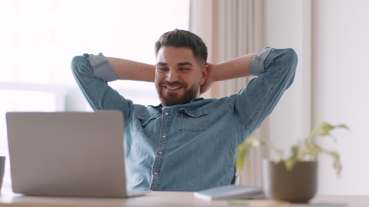 Man Relaxing at Desk with Laptop