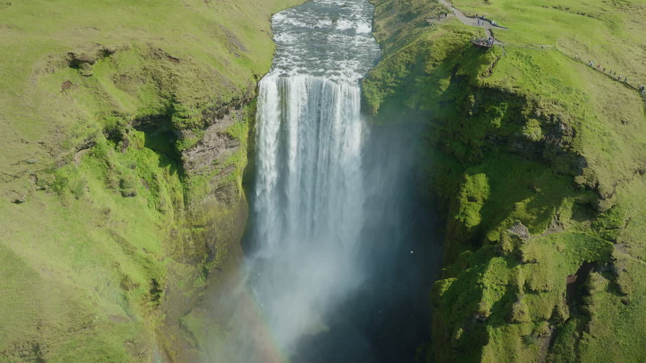 Wide aerial orbiting drone shot of Skógafoss Waterfall, Iceland, sunny day 01