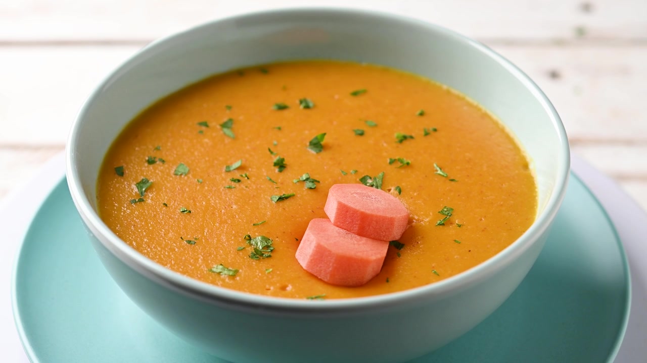 Cremet gulerodssuppe i en blå skål.