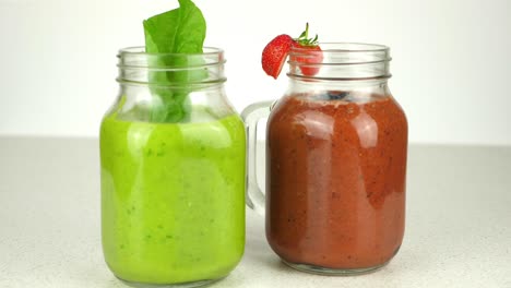 tracking shot of two appetizing smoothies, presented in novel mason jars