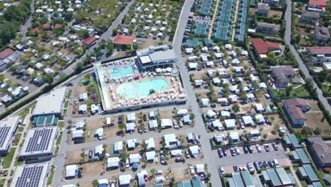 rows of small cottages surround the main resort building with a pool and tennis court