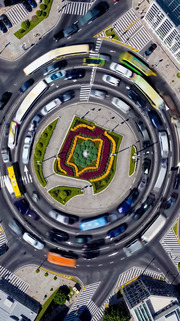 Aerial view of a roundabout with colorful vehicles in motion, creating a dynamic swirl effect