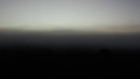 time-lapse of sunrise clearing morning mist over landscape