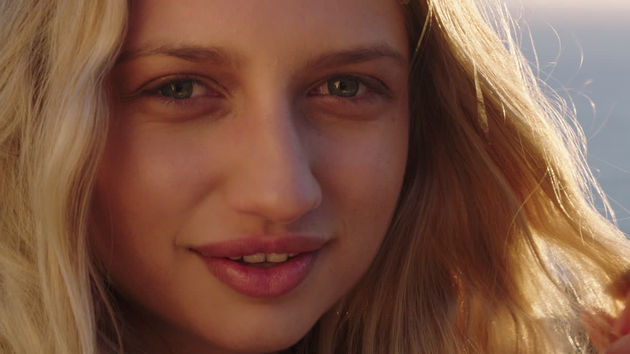 retrato de una mujer feliz riendo divirtiéndose en las vacaciones de verano disfrutando de la playa al atardecer con el viento soplando el cabello