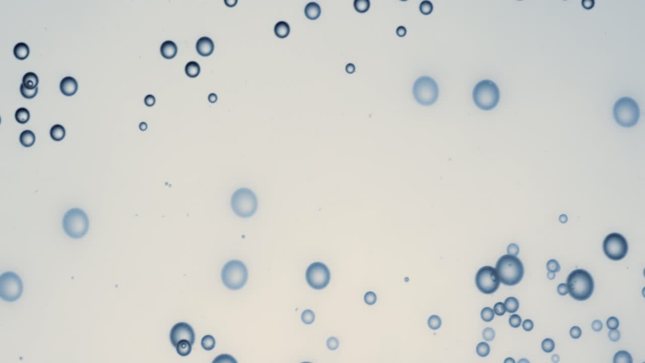 Many water bubbles in blue water close up, abstract water wave with bubbles in slow motion.