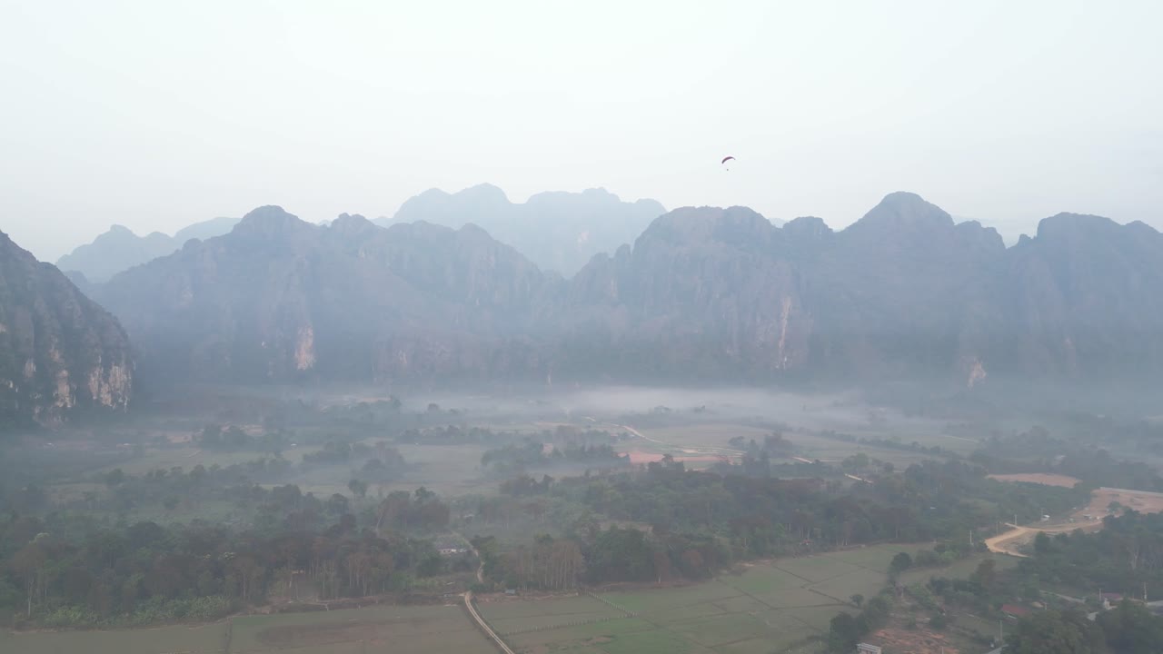 drone shot of foggy morning in the valley in Vang Vieng, the adventure capital of Laos