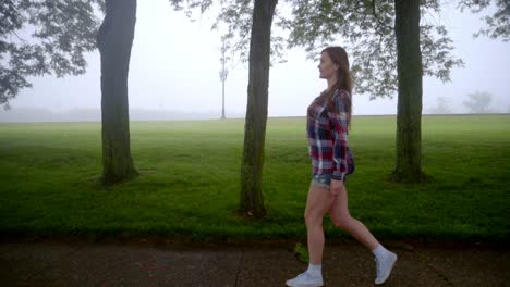 mujer joven caminando en el parque. vista de perfil de la niña caminando