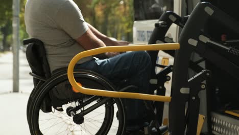 a man in a wheelchair on a lift of a vehicle for people with disabilities. lifting equipment for people with disabilities - man in wheelchair near the vehicle