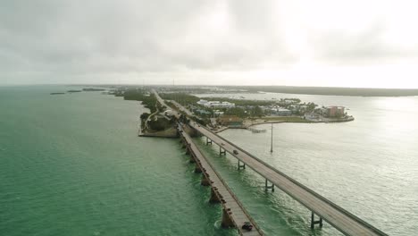 Vista-Aérea-Del-Puente-De-Siete-Millas-En-Los-Cayos-De-Florida-En-Un-Hermoso-Día-Con-Hermosas-Aguas-Turquesas-En-Cámara-Lenta-Siguiendo-A-La-Derecha